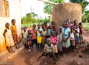 School children in Kayunga District in front of a completed rainwater harvesting tank.